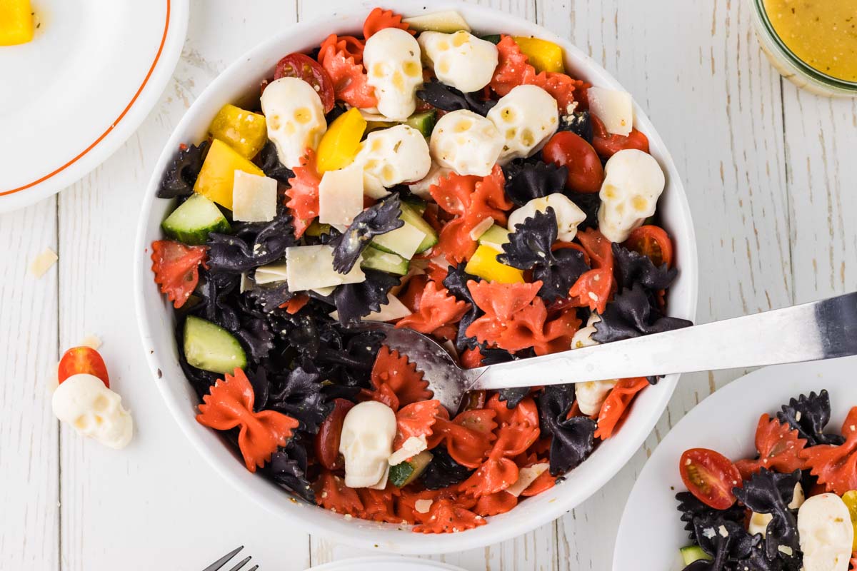 Halloween pasta salad in a large bowl with a spoon.