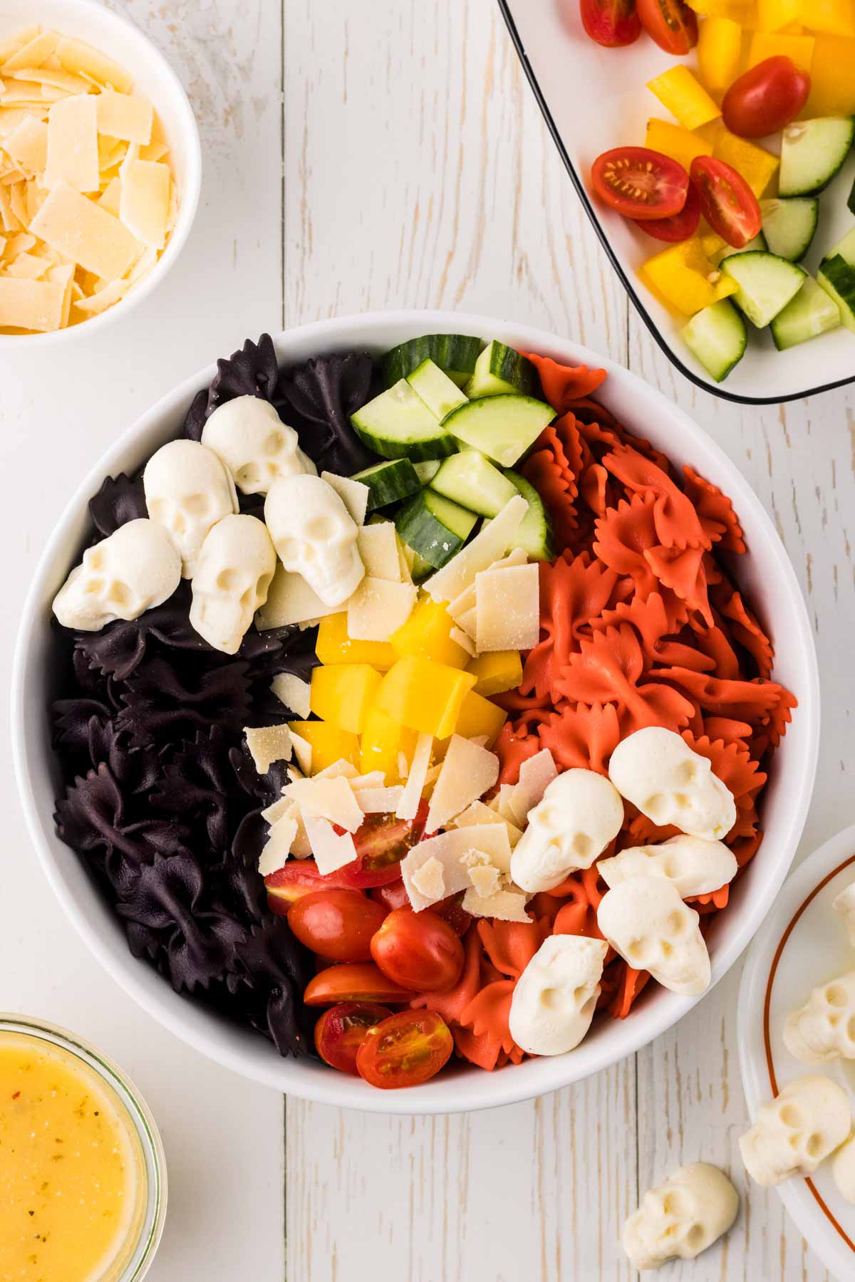 Ingredients for a spooky fall salad in a bowl before being tossed with the dressing.