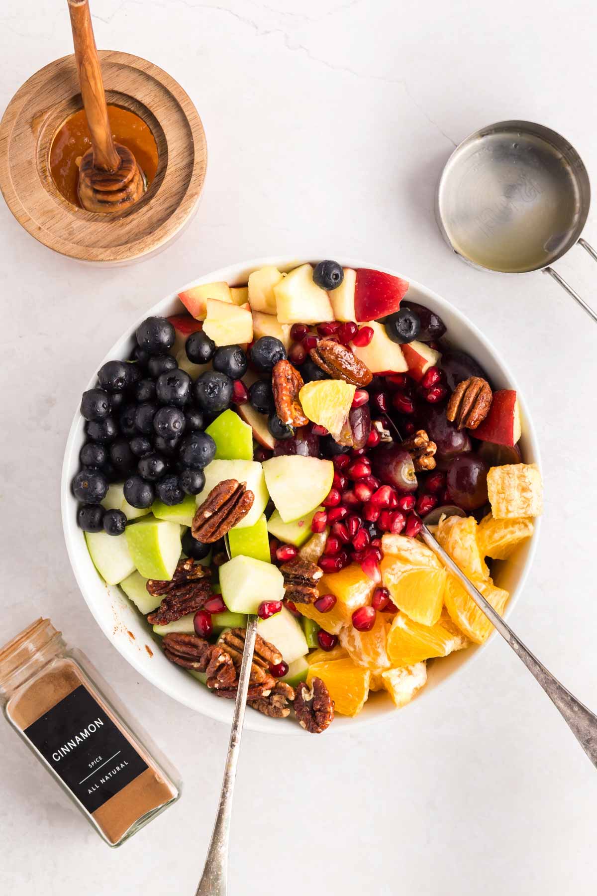 All the ingredients for a thanksgiving fruit salad in a bowl before being tossed with the dressing.