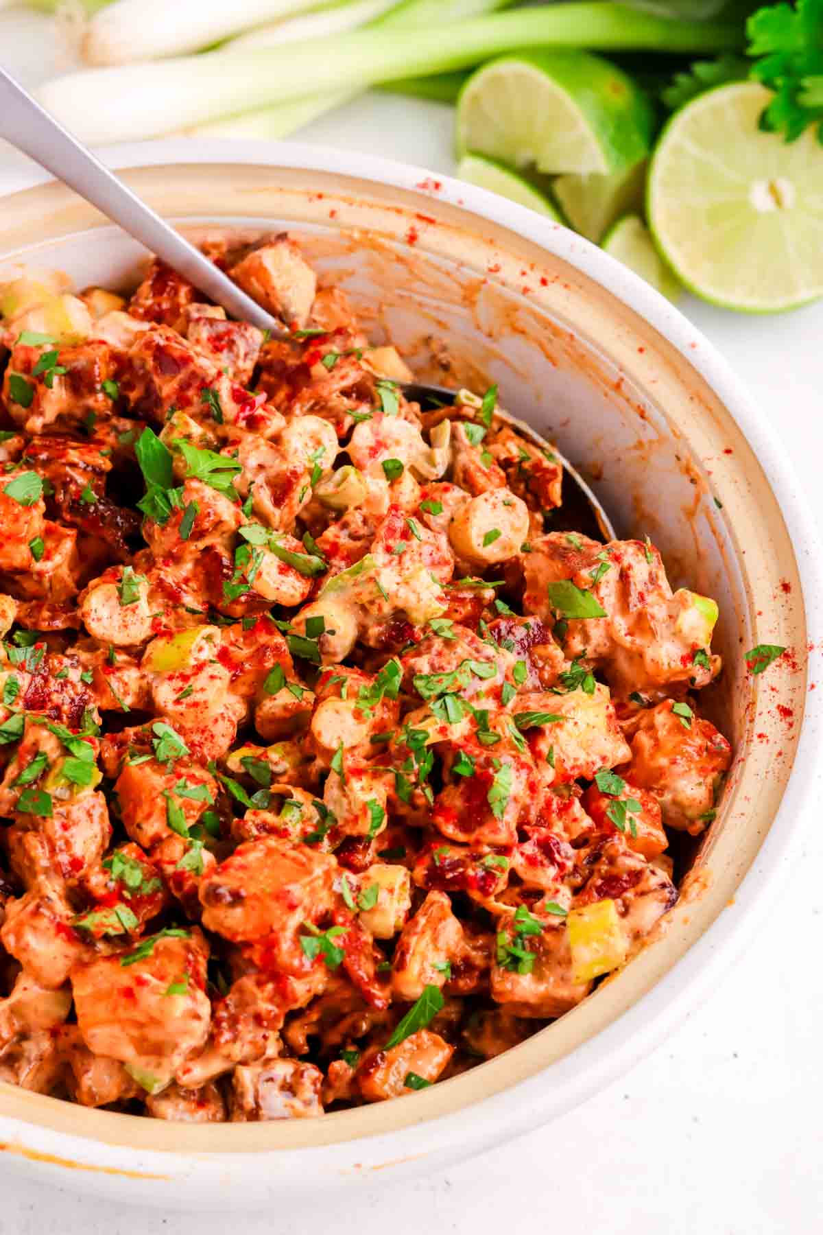 Chipotle potato salad in a white bowl with a spoon.