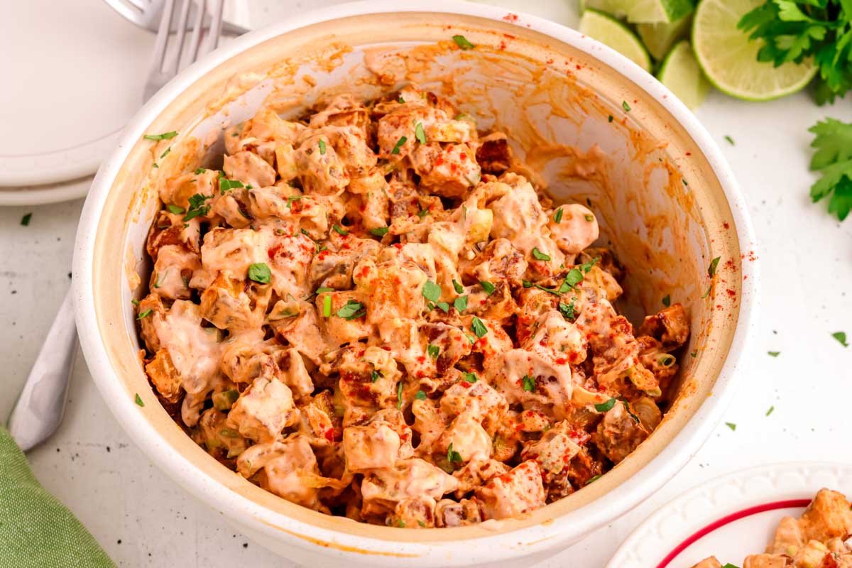 Roasted potato salad in a white bowl with southwest salad dressing. 
