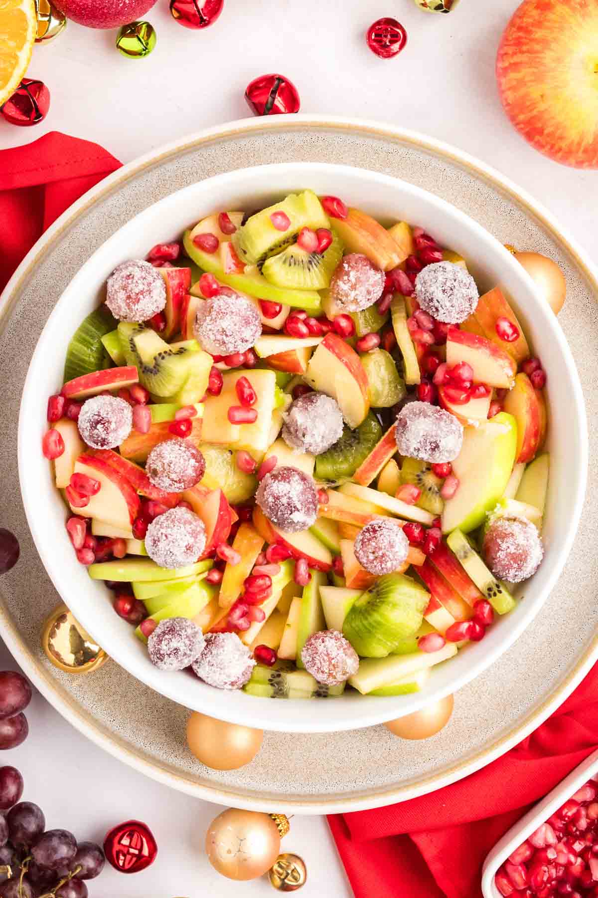 Winter fruit salad in a white bowl in a festve scene.