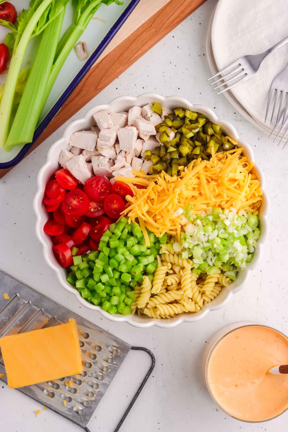 All of the ingredients for the buffalo ranch pasta salad in a bowl before being tossed. 