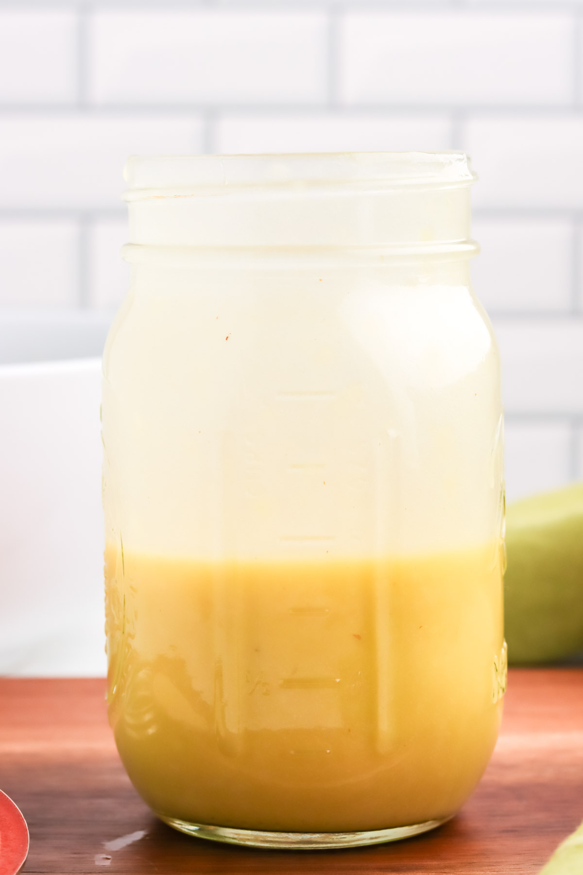 A glass mason jar with easy dijon vinaigrette dressing.